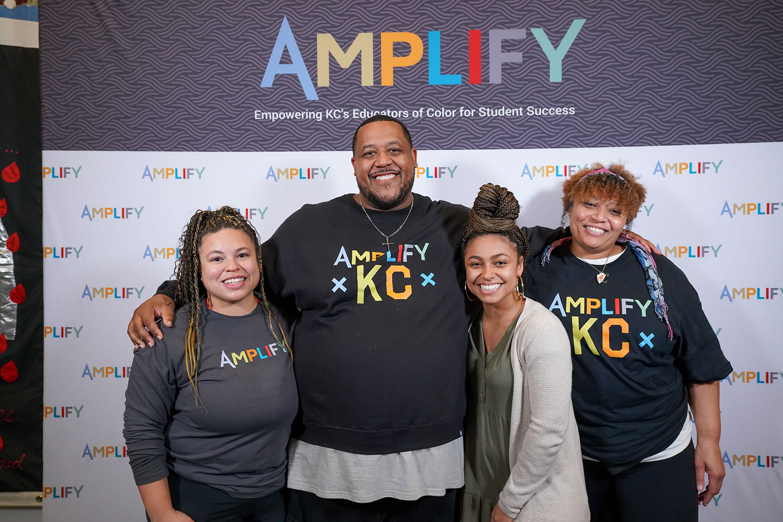 Amplify attendees pose in front of the Amplify Conference backdrop