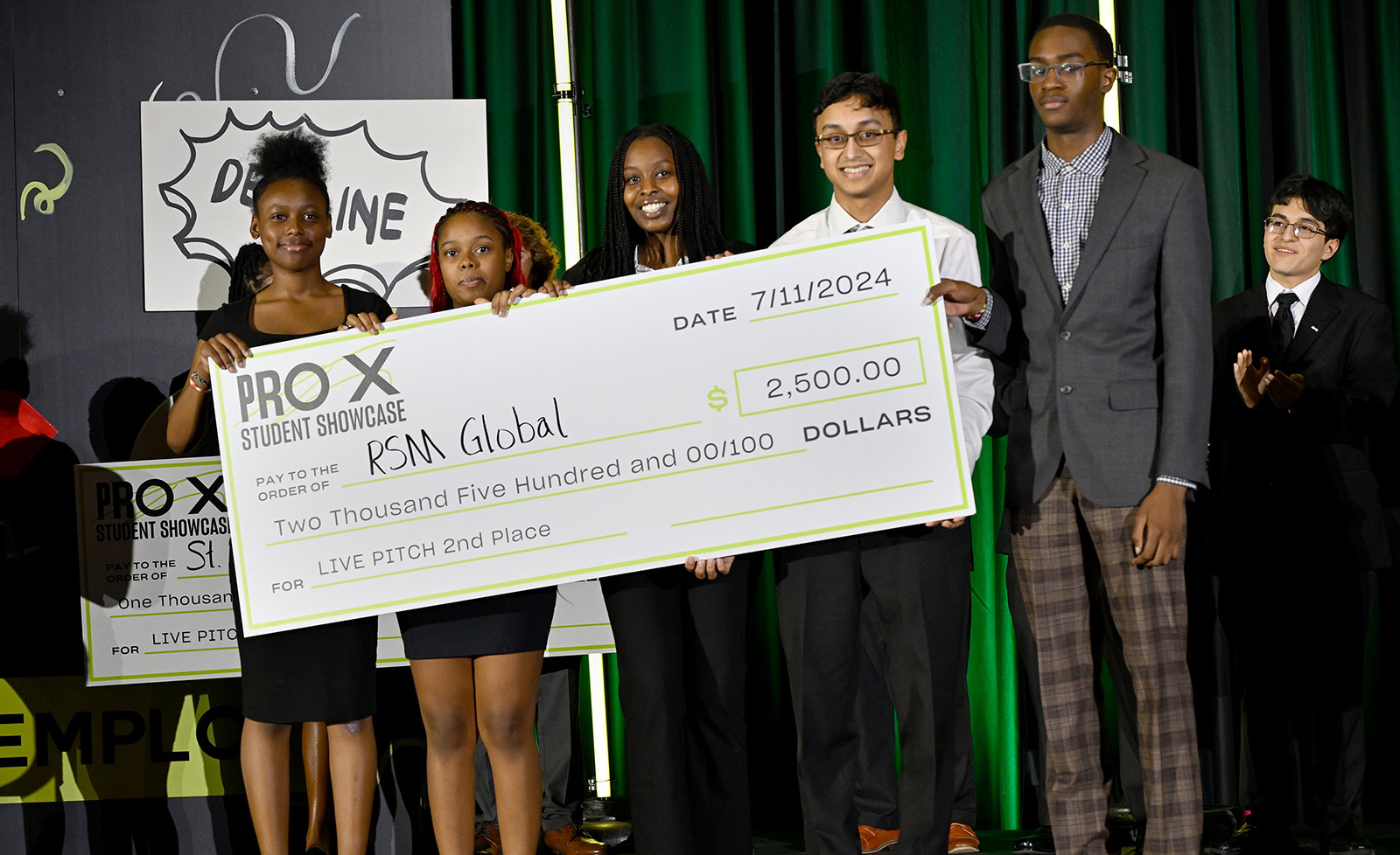 ProX summer interns hold a life-sized check at the ProX showcase