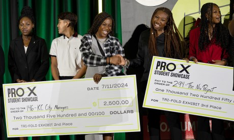 ProX interns hold life-sized checks at the ProX showcase event.