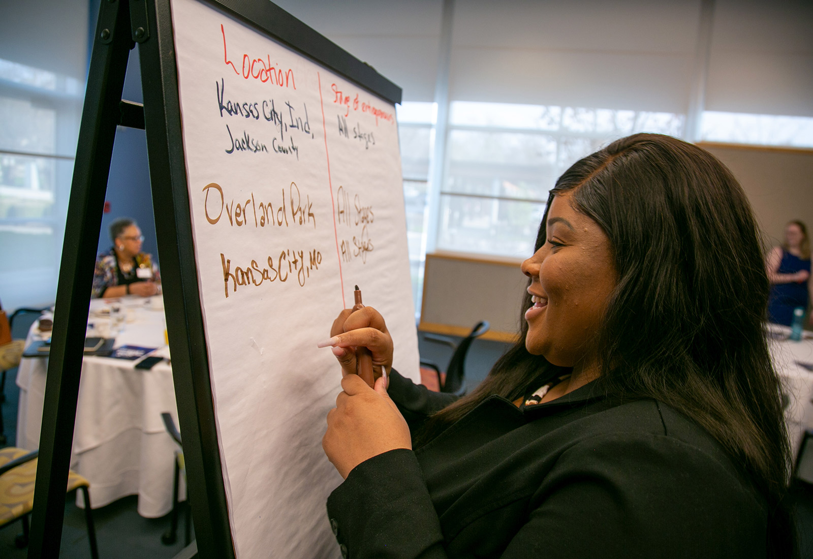 A woman writes on a large piece of paper