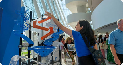 A TEDxKC attendee participates in the Kauffman Foundation acrylic heart installation at the Kauffman Center for Performing Arts